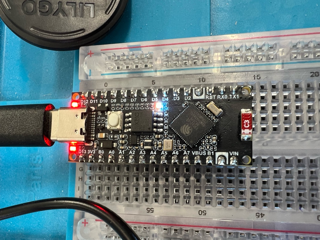 Arduino Nano ESP32 powered over USB on a breadboard, with its LEDs illuminated
