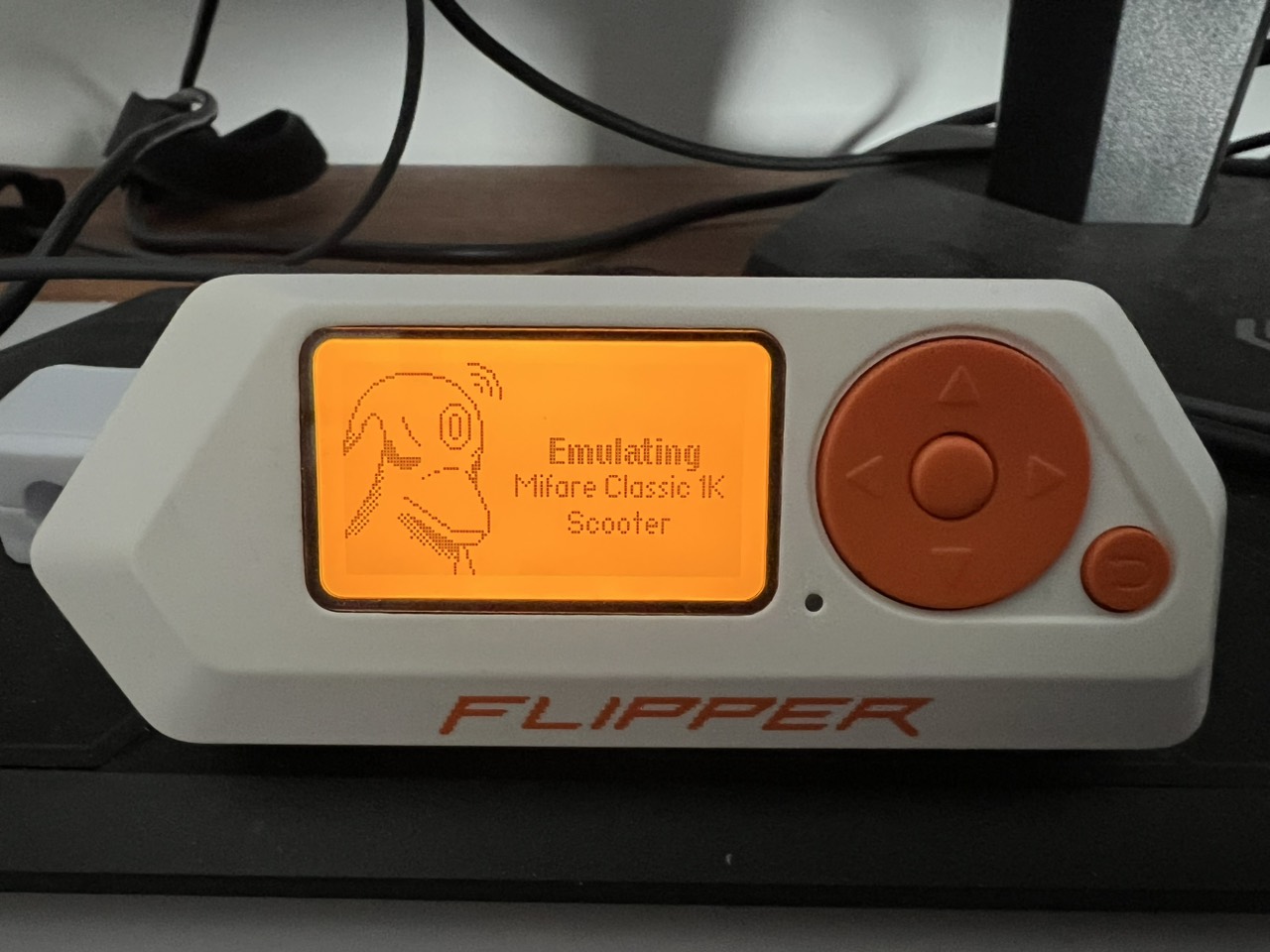 Flipper Zero displaying Emulating, Mifare Classic 1K and the saved card name Scooter